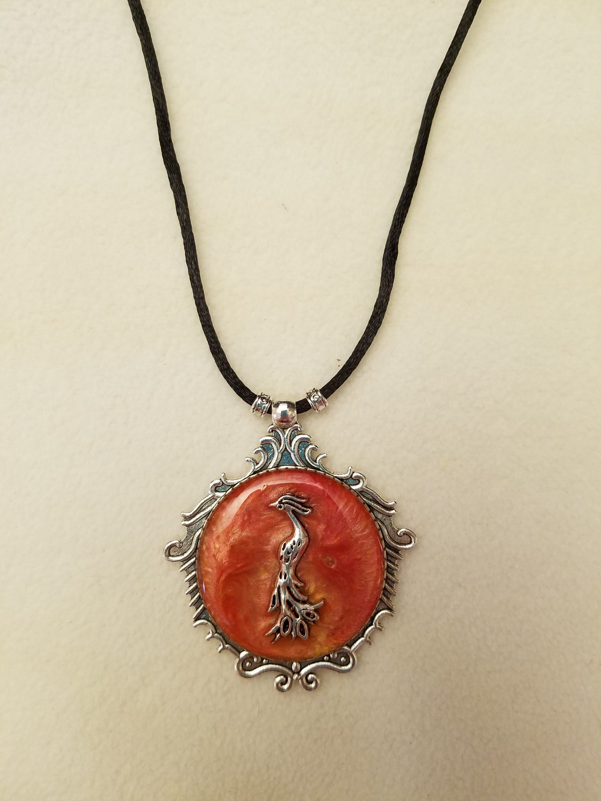 Silver Phoenix Set in Orange Swirled Epoxy on Decorative Silver Pendant