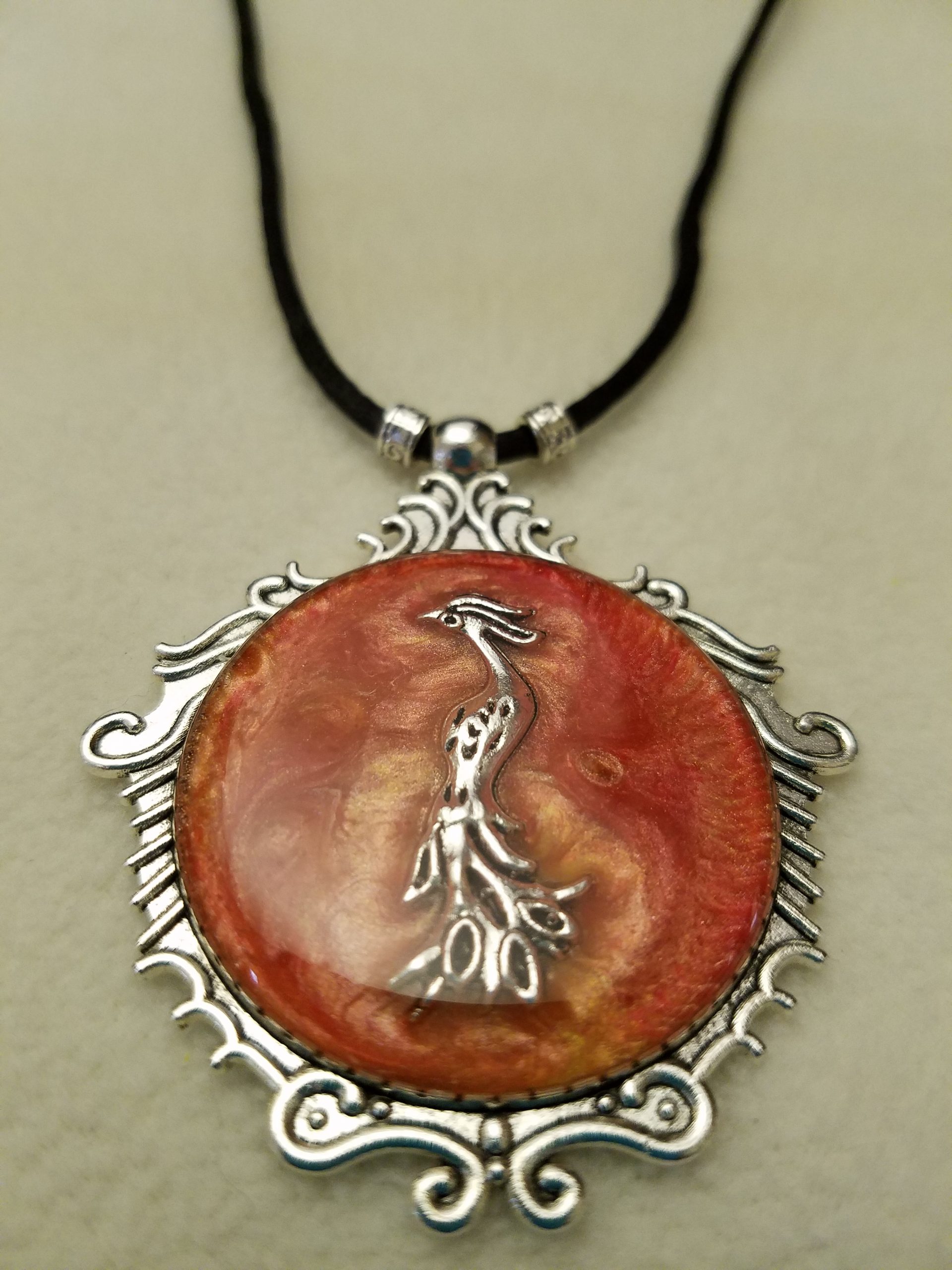 Silver Phoenix Set in Orange Swirled Epoxy on Decorative Silver Pendant