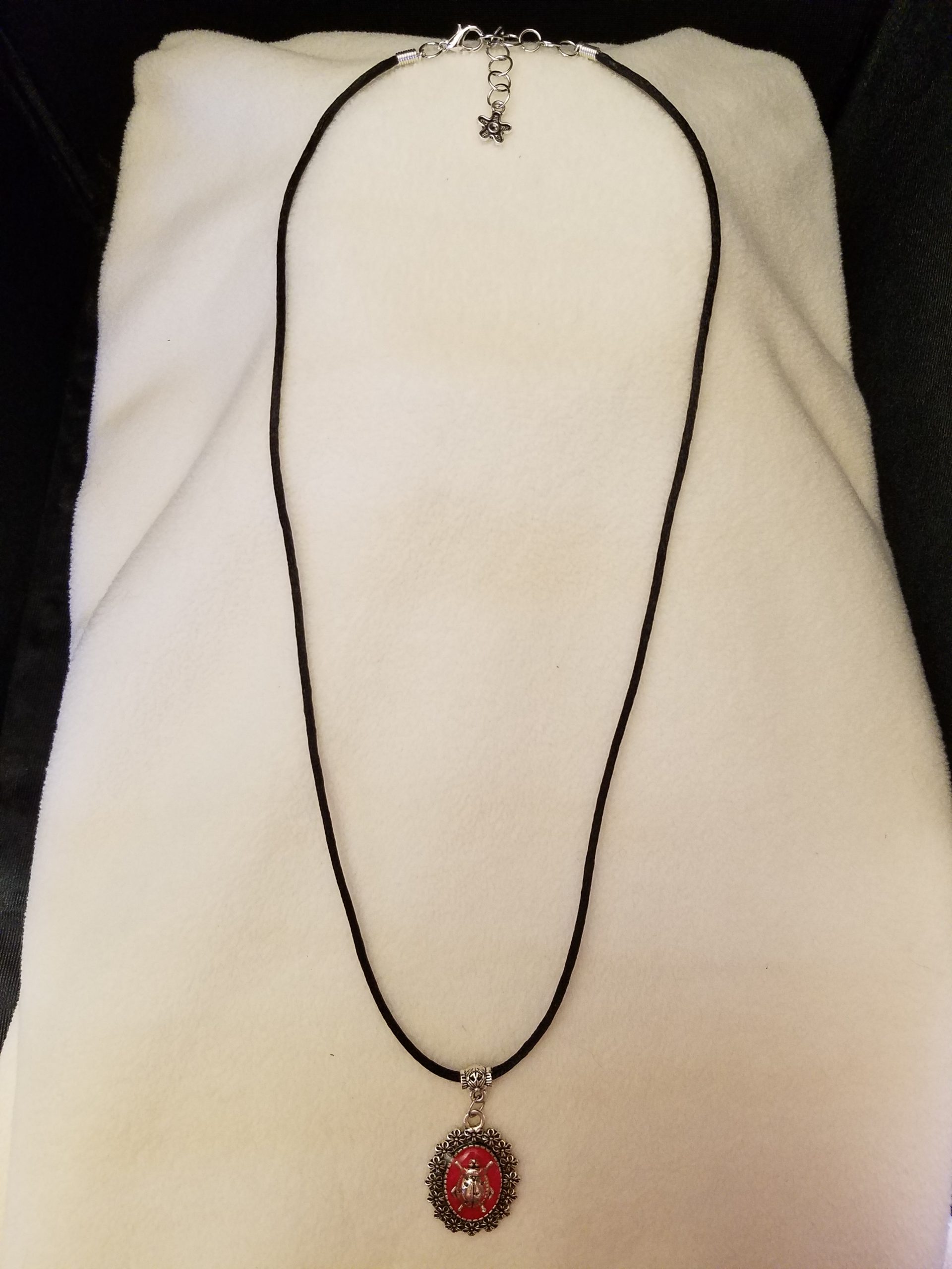Adjustable Black Cord Necklace with a Silver Ladybug in Red Epoxy on Decorative Flower Pendant