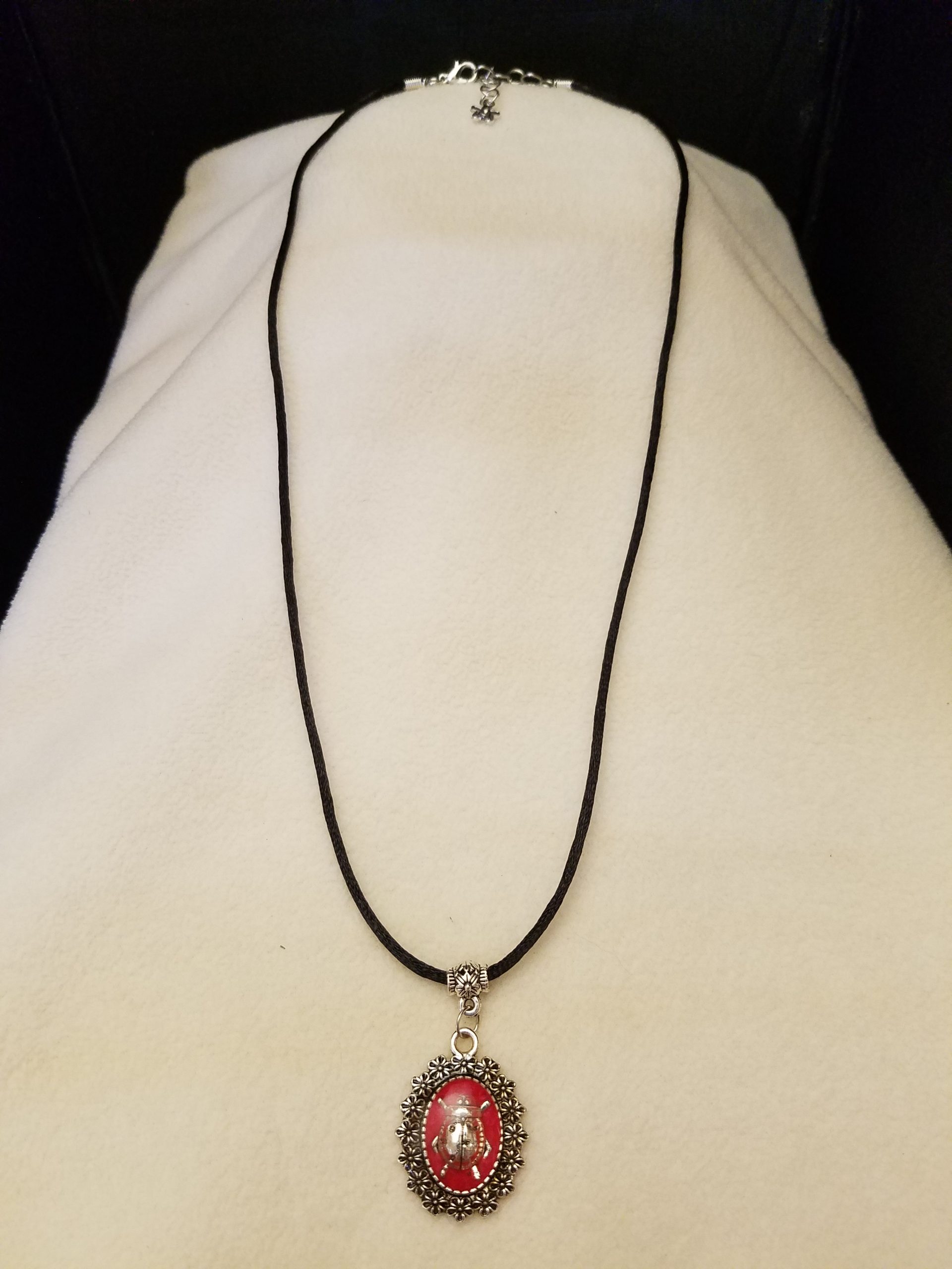 Adjustable Black Cord Necklace with a Silver Ladybug in Red Epoxy on Decorative Flower Pendant