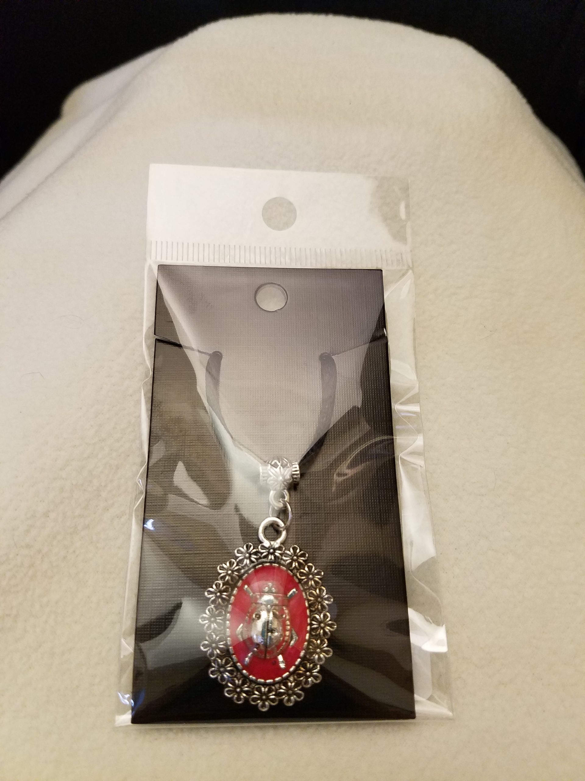 Adjustable Black Cord Necklace with a Silver Ladybug in Red Epoxy on Decorative Flower Pendant