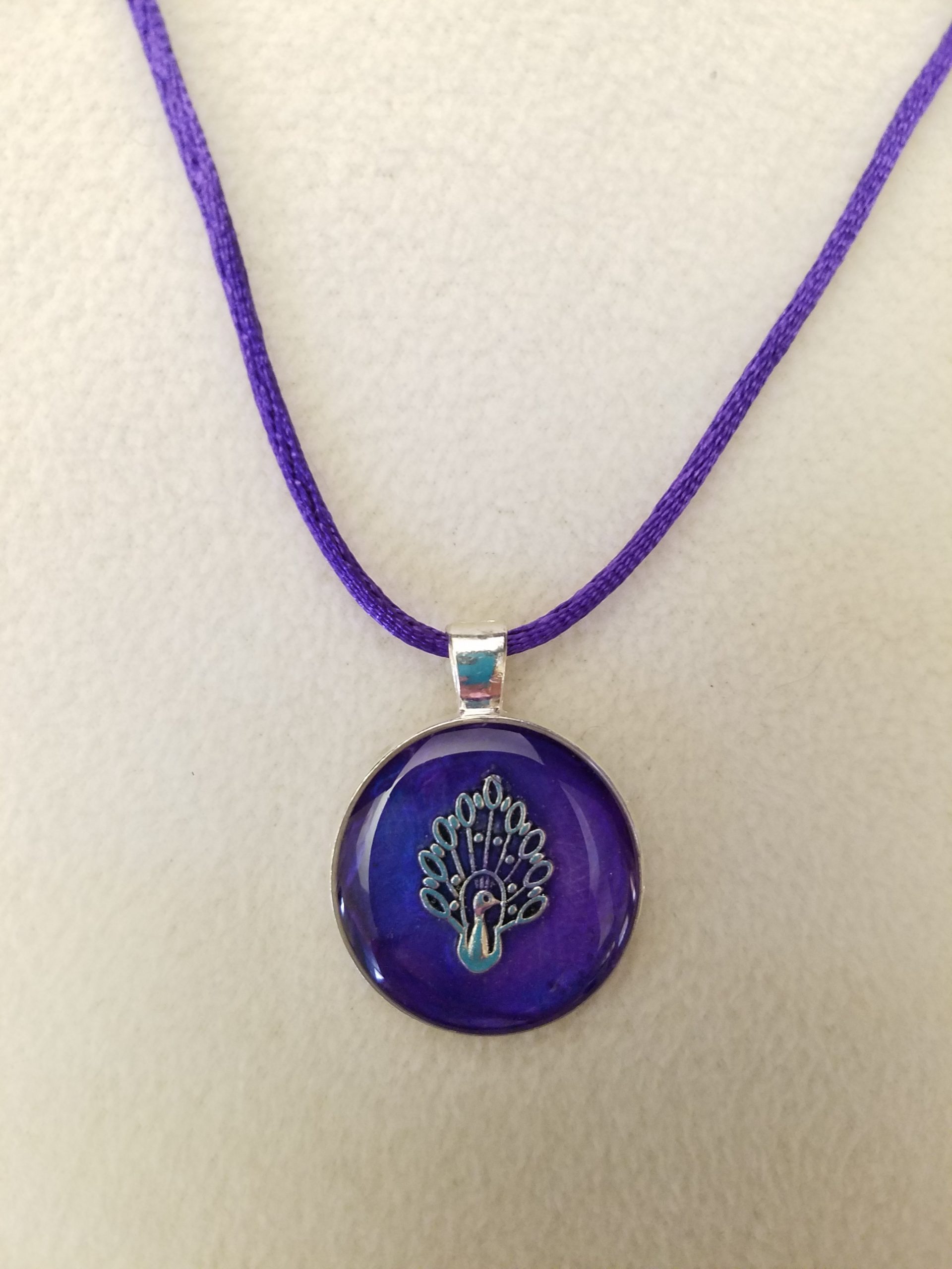 Silver Peacock in Purple Epoxy on a Round Silver Pendant on Purple Cord Necklace