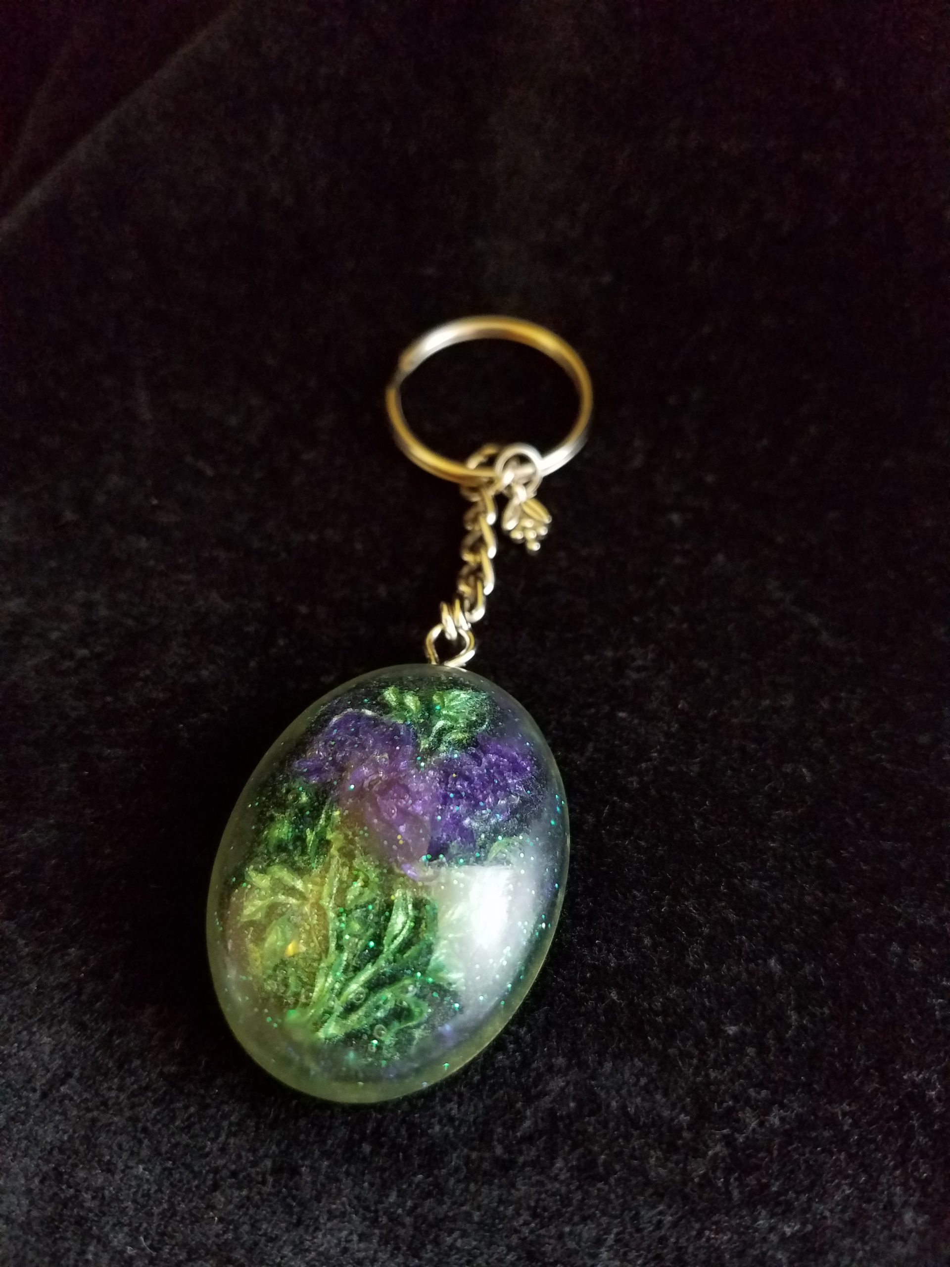 Oval Pendant Keychain Filled with Purple Flower Bouquet in Clear Glitter and Green Epoxy with Silver Flower Charm