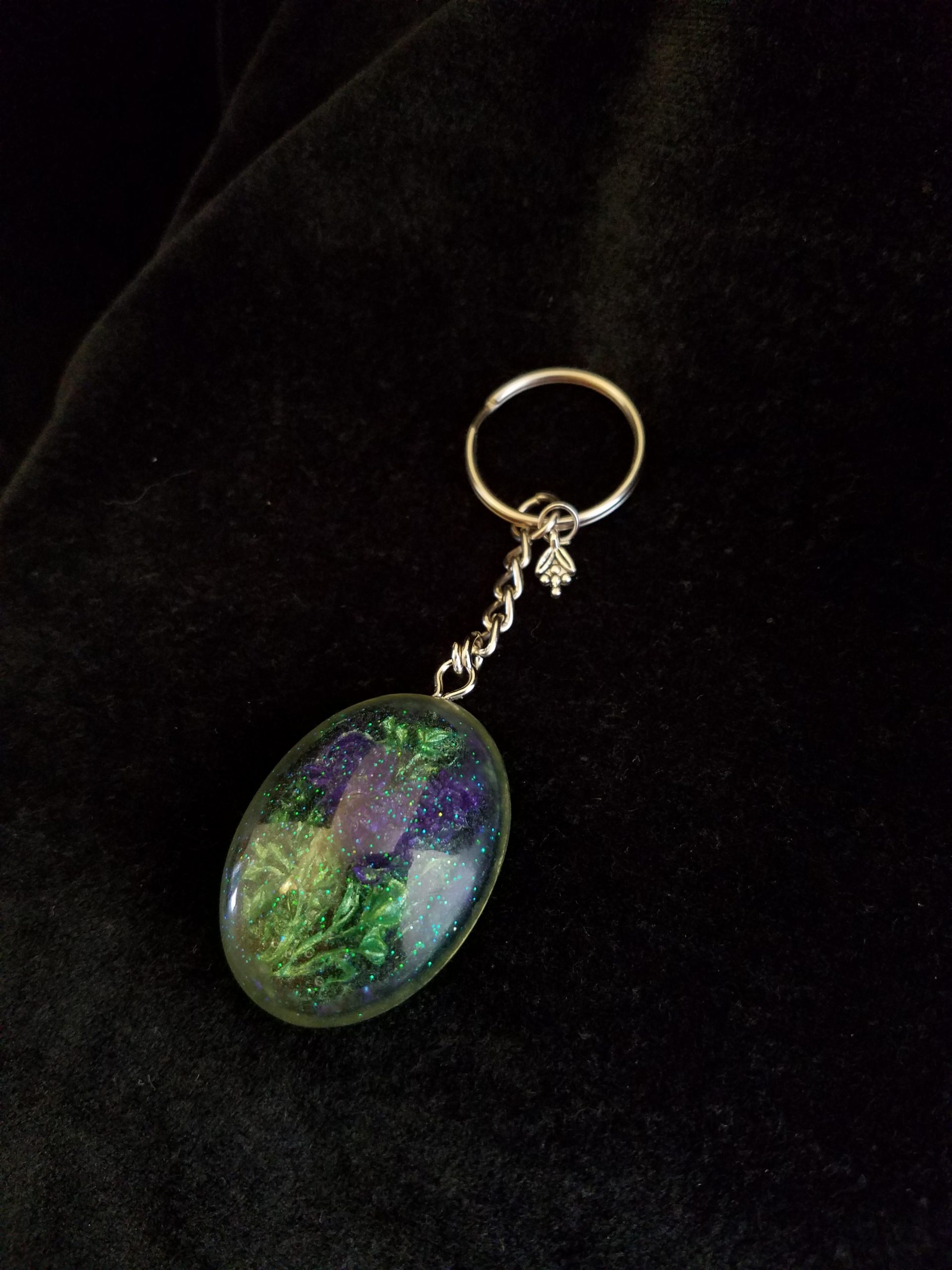 Oval Pendant Keychain Filled with Purple Flower Bouquet in Clear Glitter and Green Epoxy with Silver Flower Charm