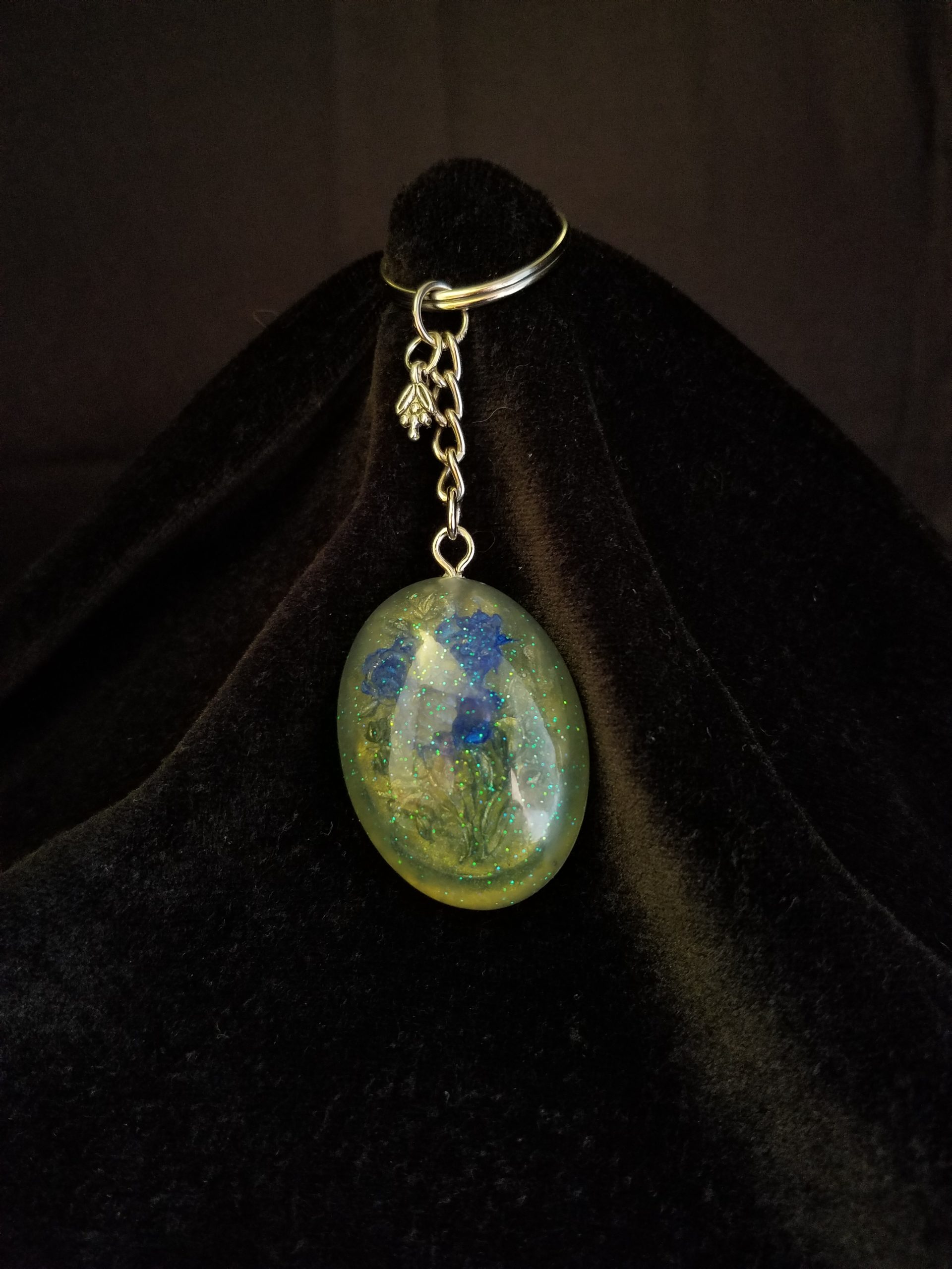 Oval Pendant Keychain Filled with Blue Flower Bouquet in Clear Glitter and Green Epoxy with Silver Flower Charm