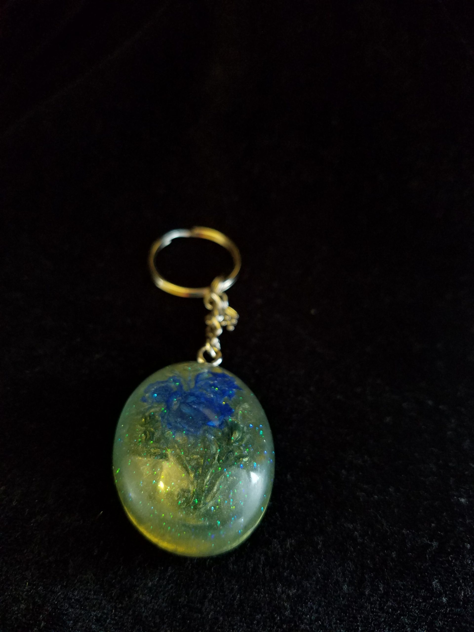 Oval Pendant Keychain Filled with Blue Flower Bouquet in Clear Glitter and Green Epoxy with Silver Flower Charm