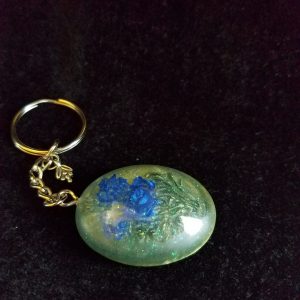 Oval Pendant Keychain Filled with Blue Flower Bouquet in Clear Glitter and Green Epoxy with Silver Flower Charm