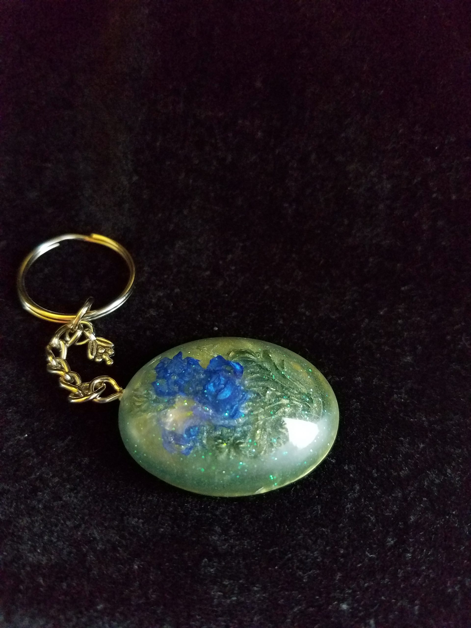 Oval Pendant Keychain Filled with Blue Flower Bouquet in Clear Glitter and Green Epoxy with Silver Flower Charm