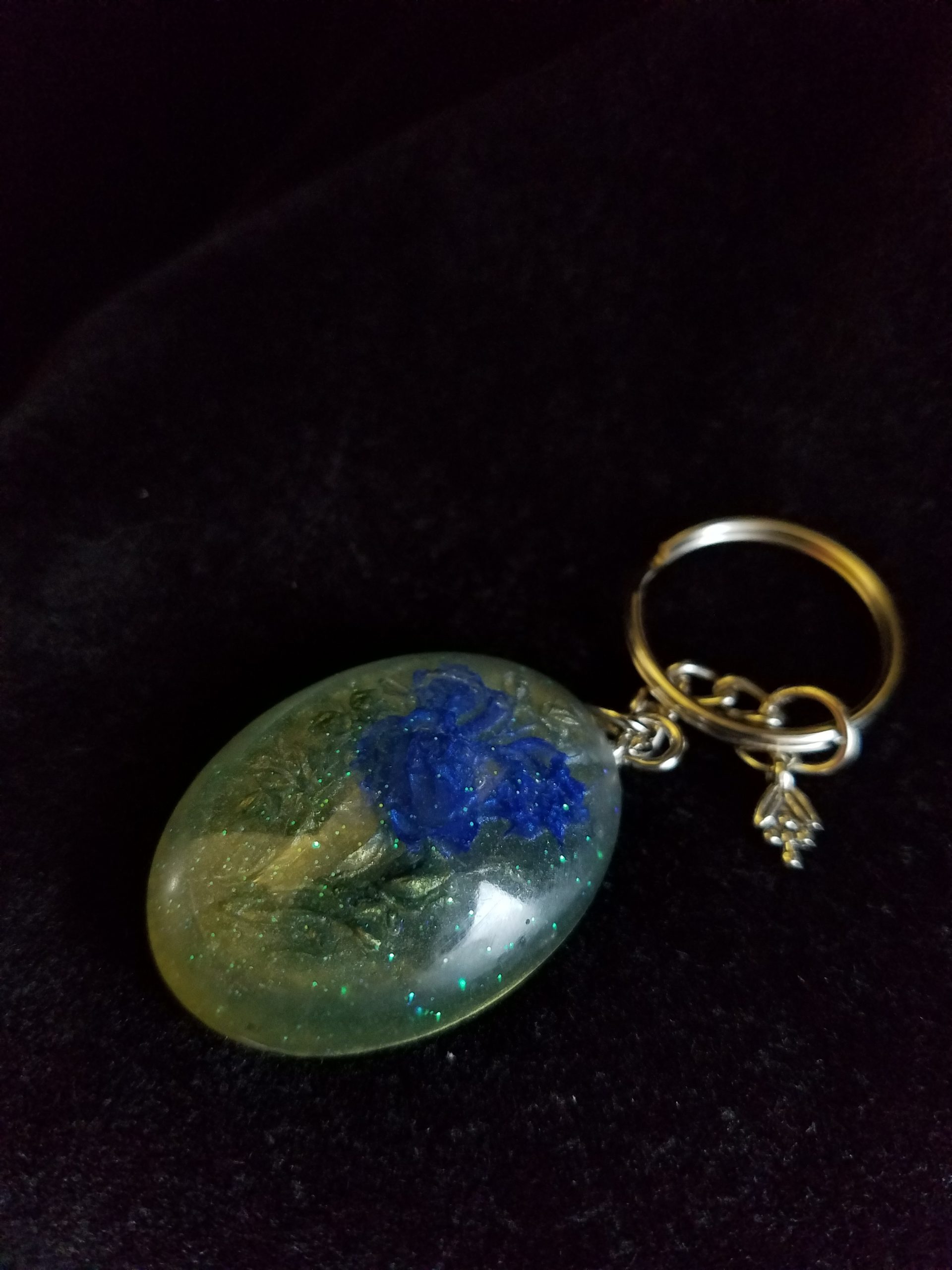 Oval Pendant Keychain Filled with Blue Flower Bouquet in Clear Glitter and Green Epoxy with Silver Flower Charm