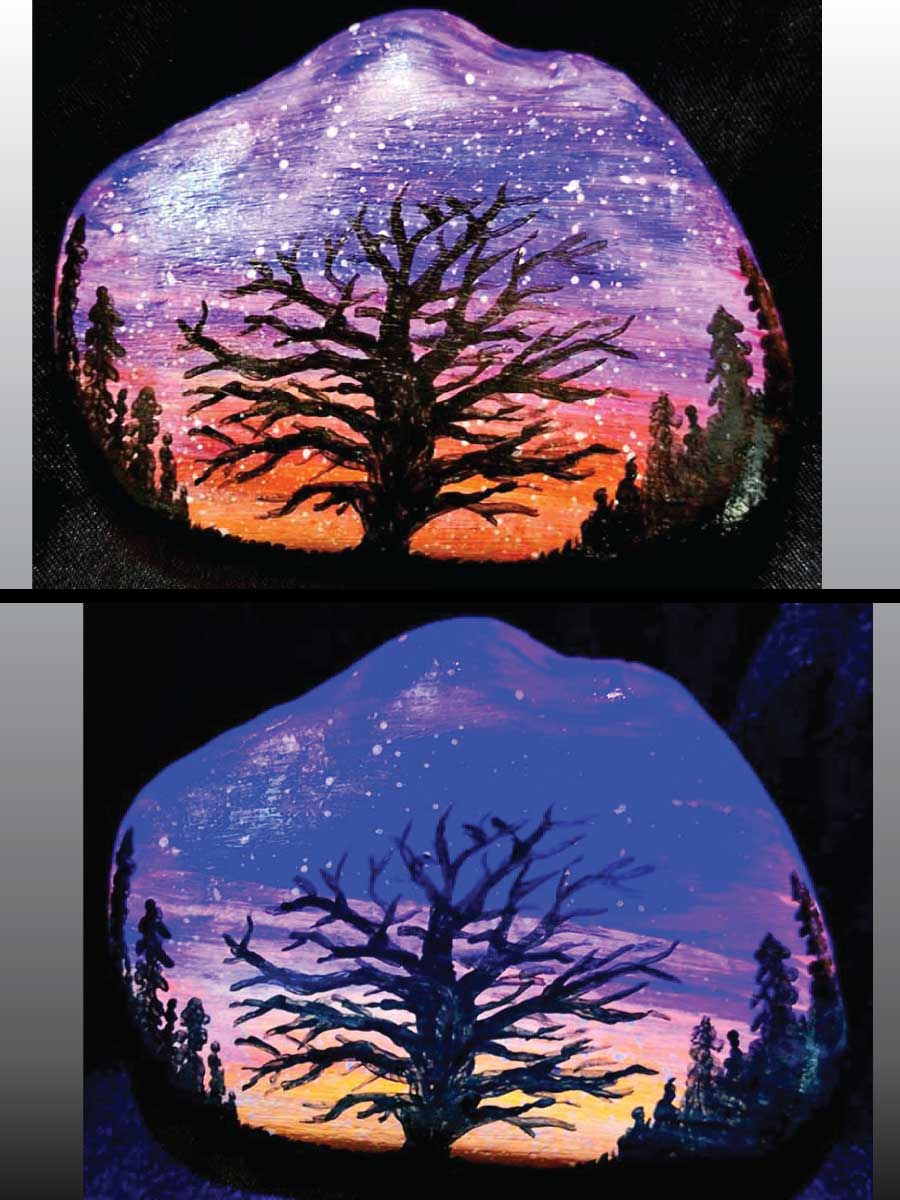 alt="Collage view with 2 images of a hand painted in acrylic paint 3 by 2.5 inch smooth rock with a neon orange red pink and purple blended sunset in the background with a black silhouette in the foreground containing an image of a country scene with a branchy leafless tree and grass in the center of the rock with full pine trees filling hills that are framing the far left and right sides of the rock, one viewed in regular light and one viewed under black light.">