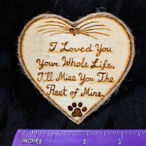 alt="Horizontal ruler measuring a 3 inch by 3 inch hand burned heart shaped wood slice magnet with pet nose and whisker art at the top and poem that says 'I loved you your whole life, I'll miss you the rest of mine,' finished with a brown twine edge border.">