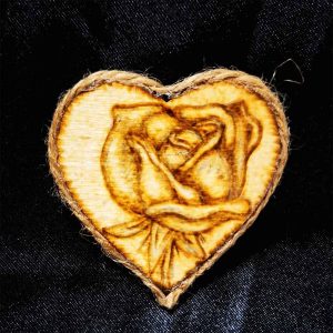 alt="Small 2 inch by 2 inch hand burned heart shaped wood slice magnet with a single rose art finished with a brown twine edge border.">