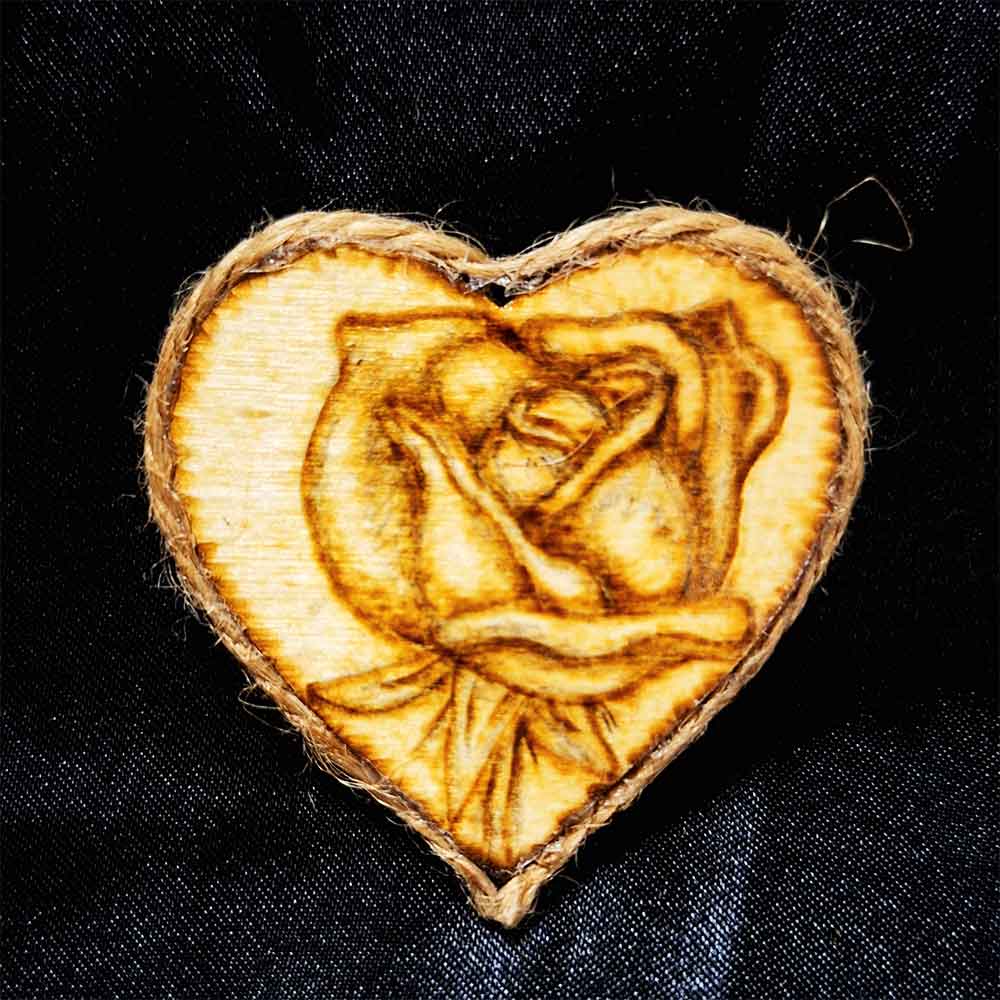 alt="Small 2 inch by 2 inch hand burned heart shaped wood slice magnet with a single rose art finished with a brown twine edge border.">